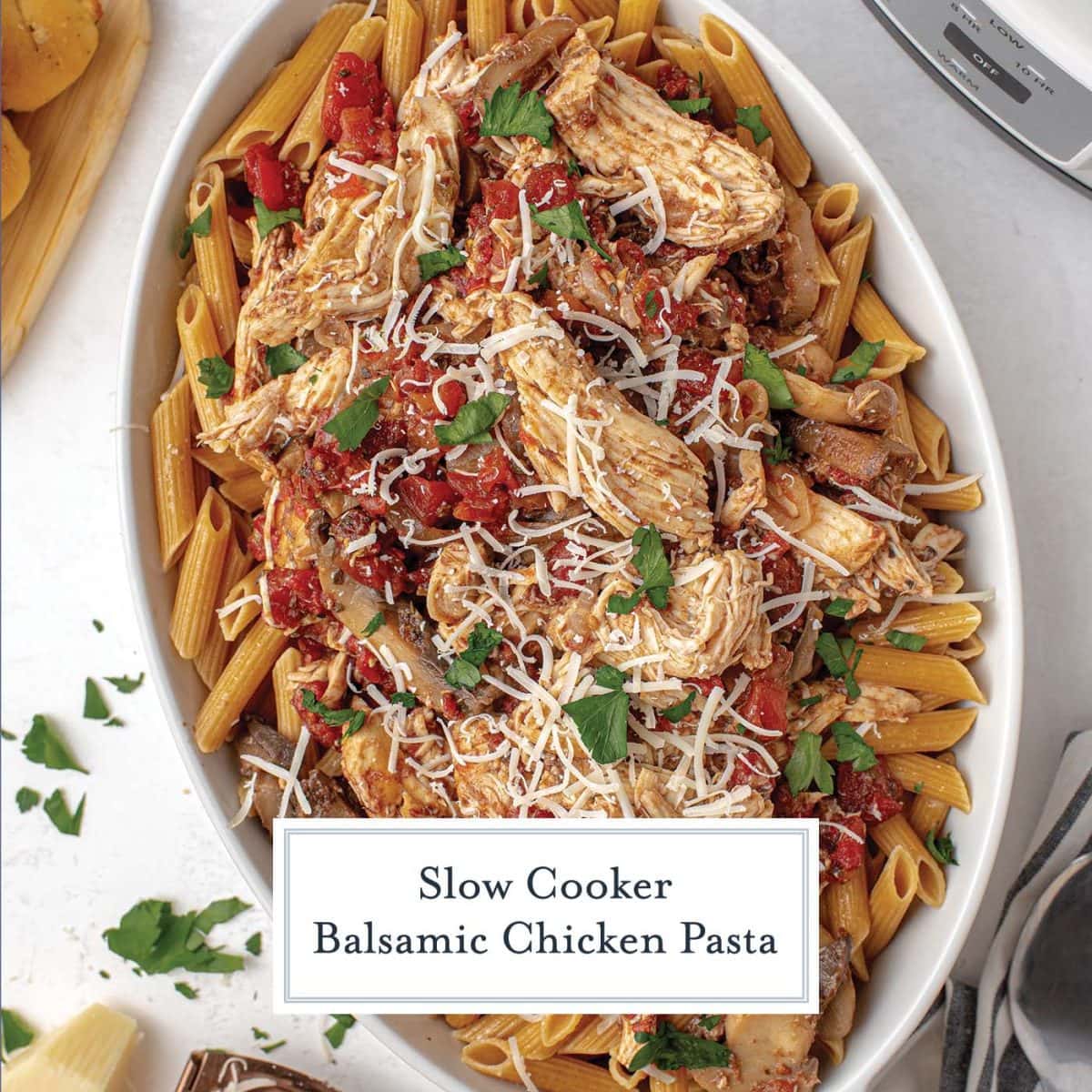balsamic chicken pasta in a white serving dish with parmesan topping