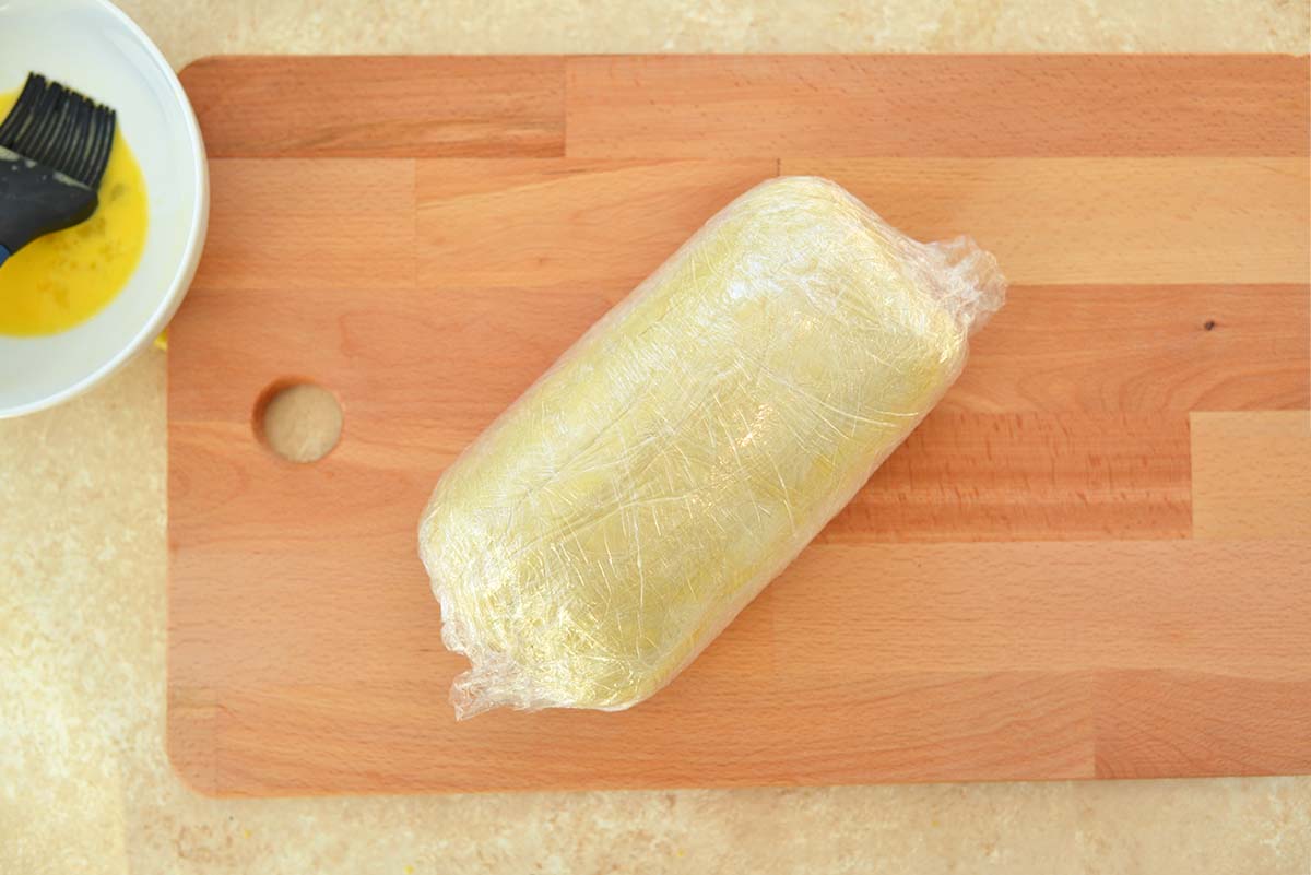 beef and puff pastry wrapped in plastic wrap 