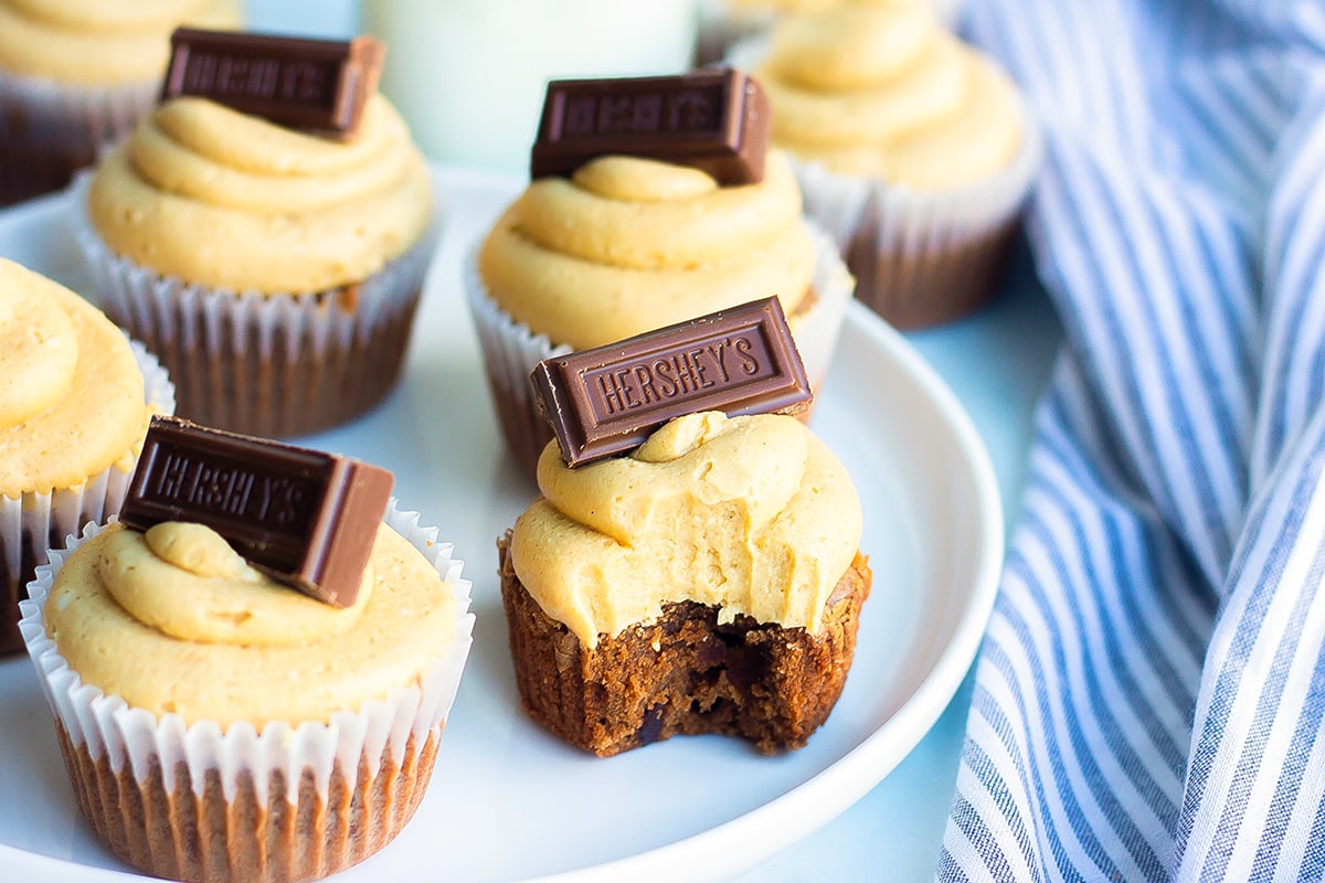 platter of brownie cupcakes and one with a bite taken out of it 