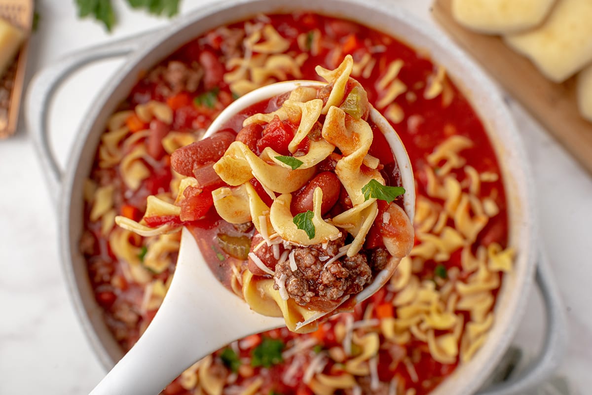 ladle of noodles, beans, tomatoes and ground beef 