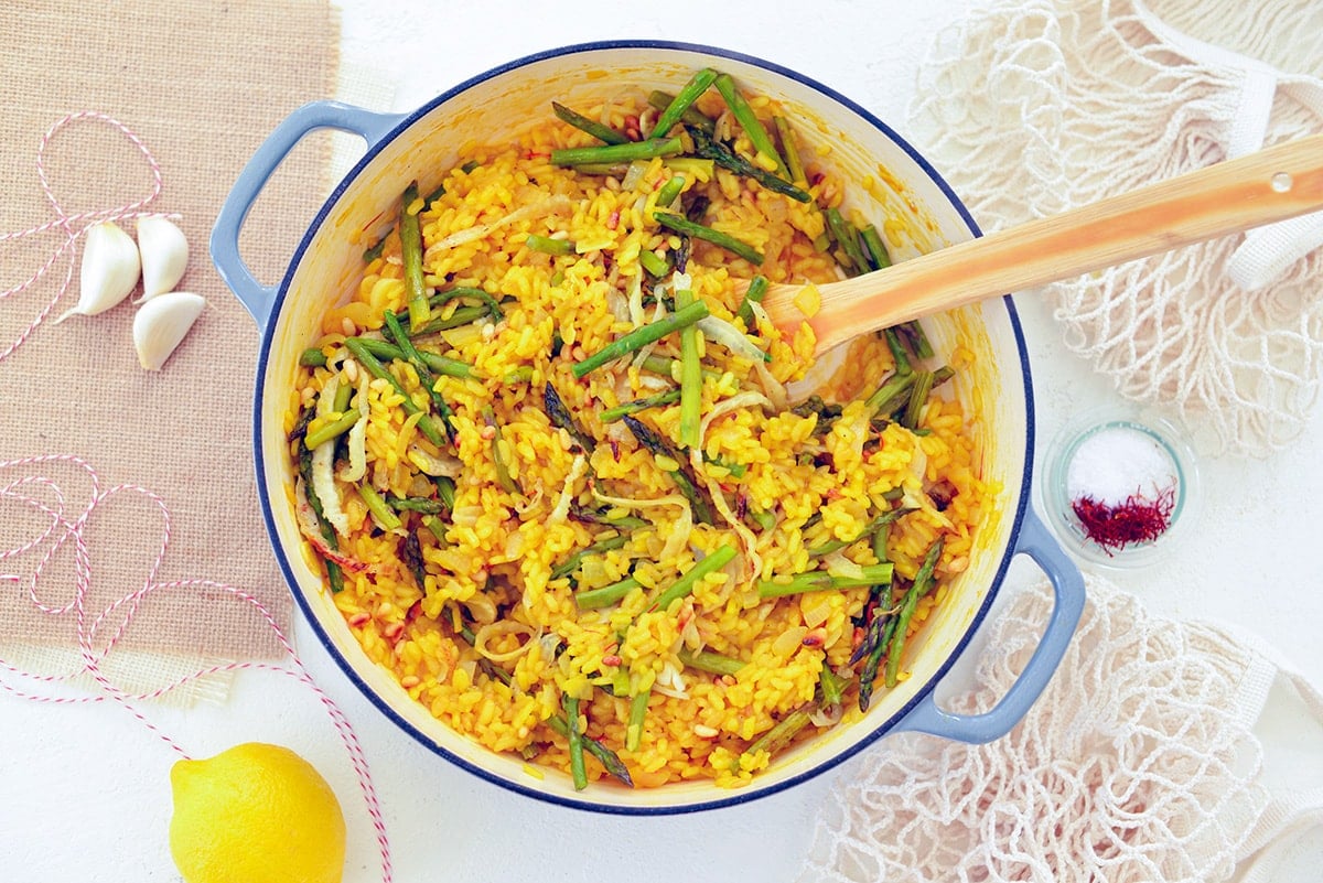 overhead shot of wooden spoon in pan of lemon saffron risotto