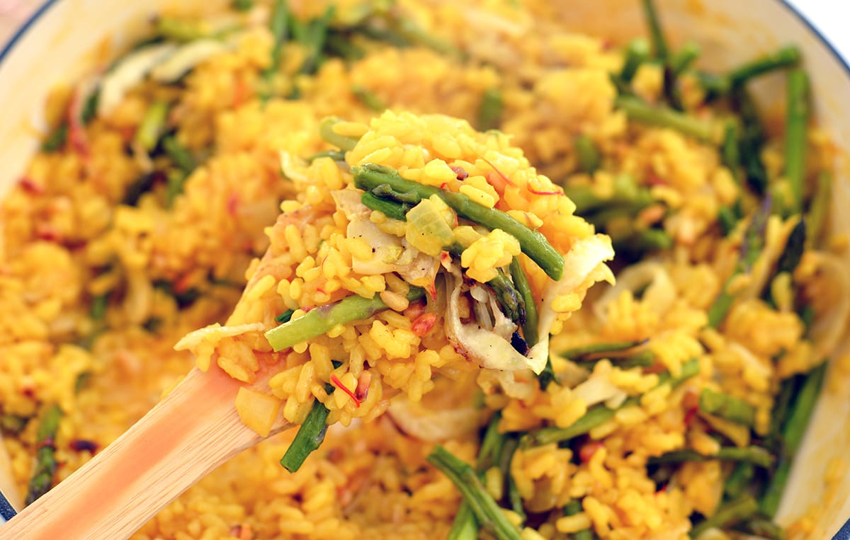 close up of lemon saffron risotto on wooden spoon