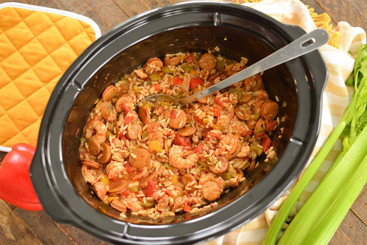 cooked jambalaya in a slow cooker with an oven mitt and produce 
