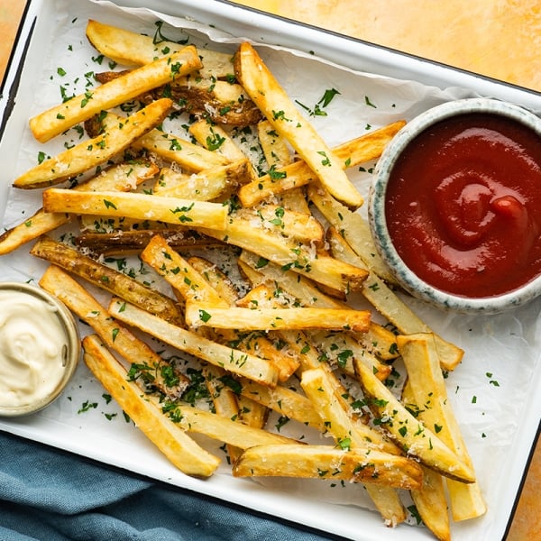 overhead of a tray of french fries with dipping sauces