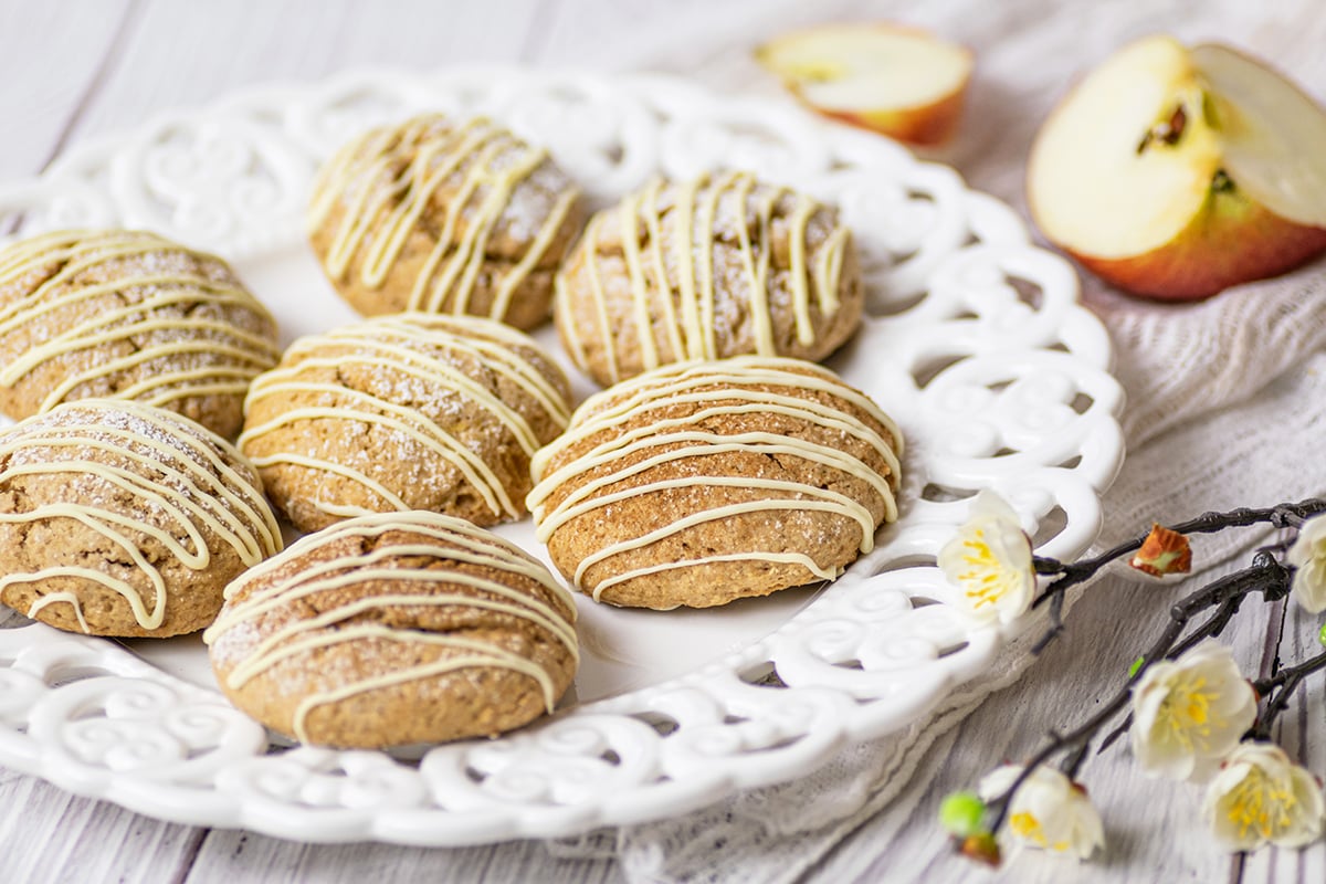 angle view of soft applesauce cookies with white chocolate drizzle 