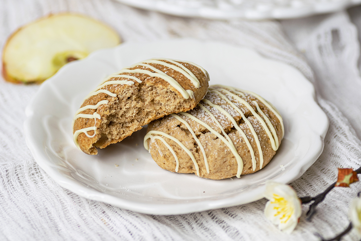 two cookies on a plate, one with a bite taken out of it 