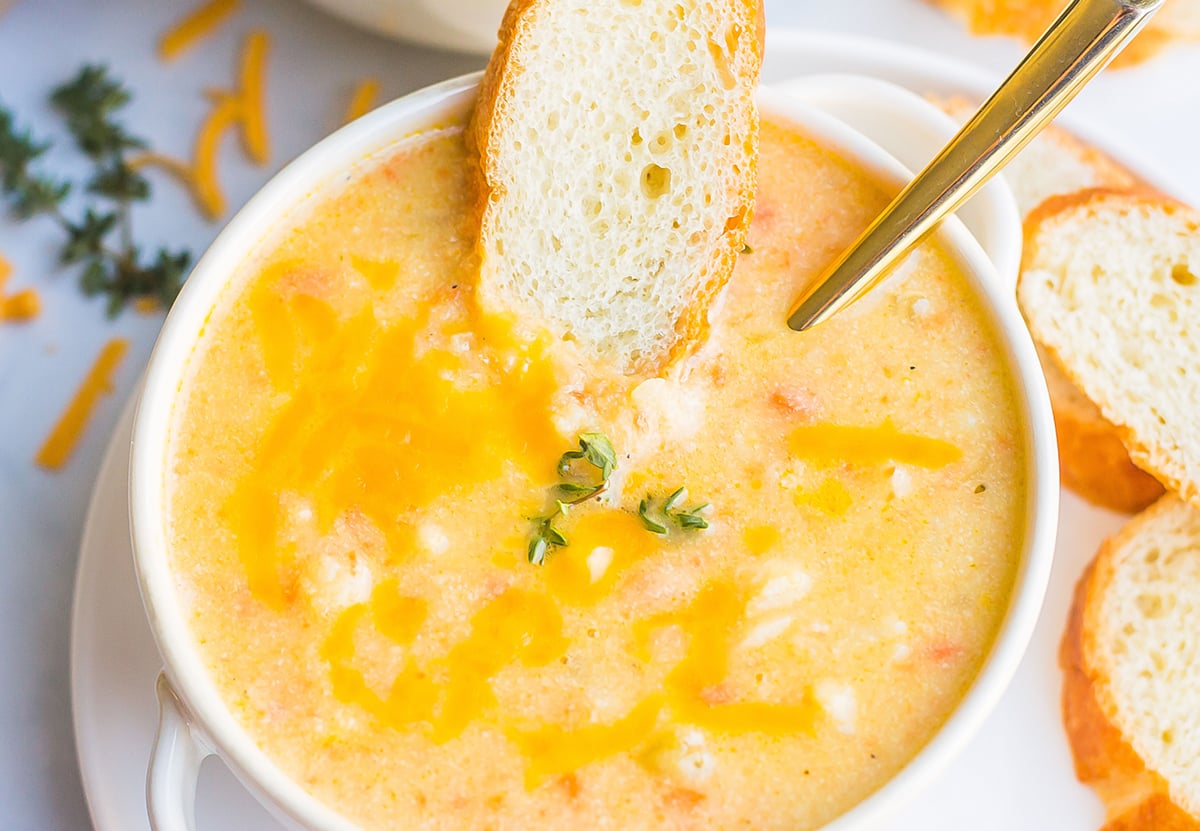 crusty bread in a bowl of cheesy soup 