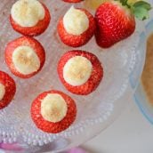 overhead of cheesecake stuffed strawberries on a glass serving plate