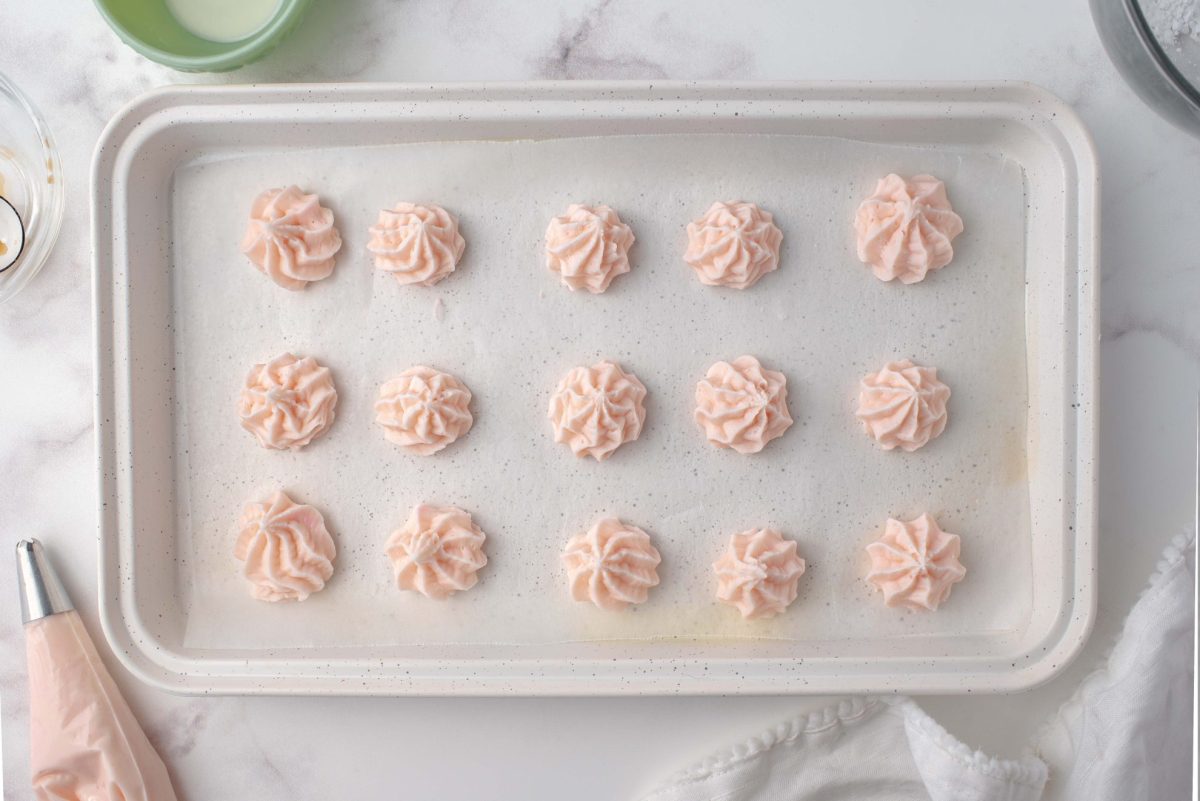 cream cheese candy piped onto wax paper on a baking sheet 