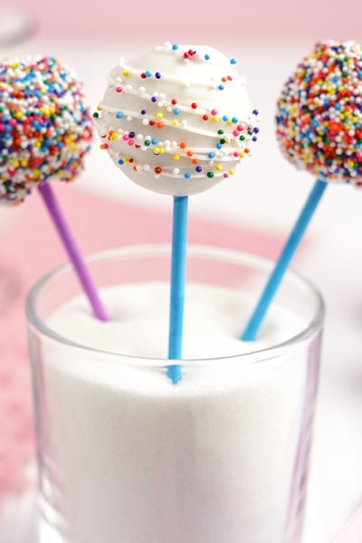 angled shot of three cake pops in a glass