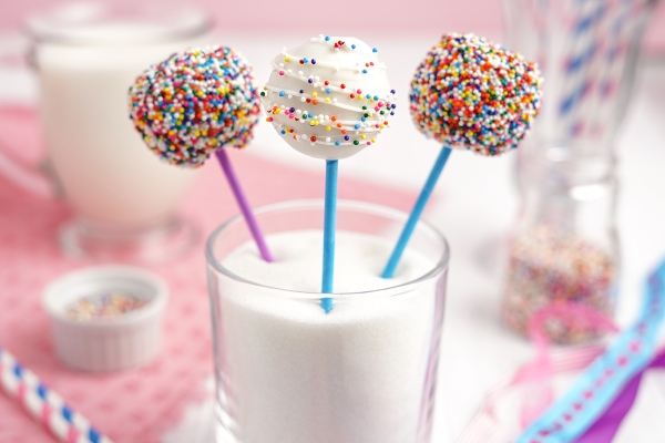 angled shot of three cake pops in a glass