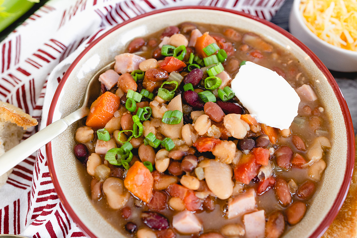 overhead shot of bowl of 15 bean soup topped with sour cream