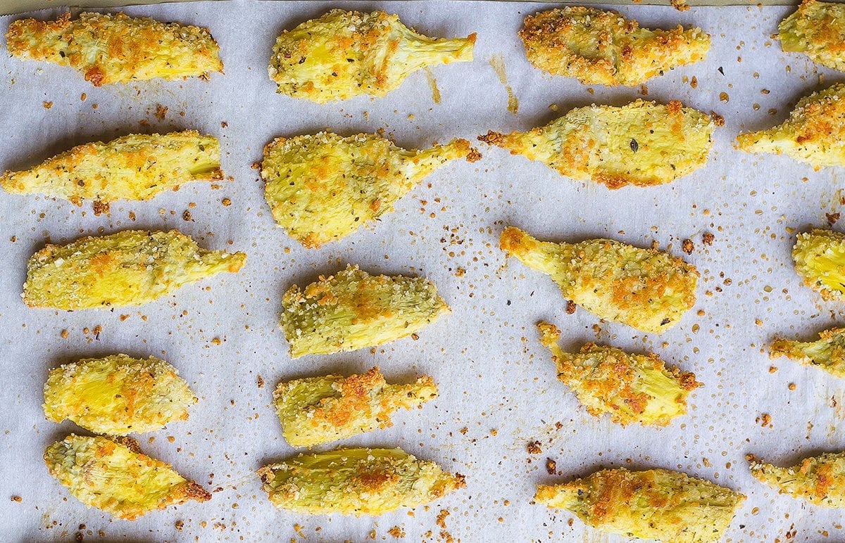 browned breaded artichokes on a parchment lined baking sheet 