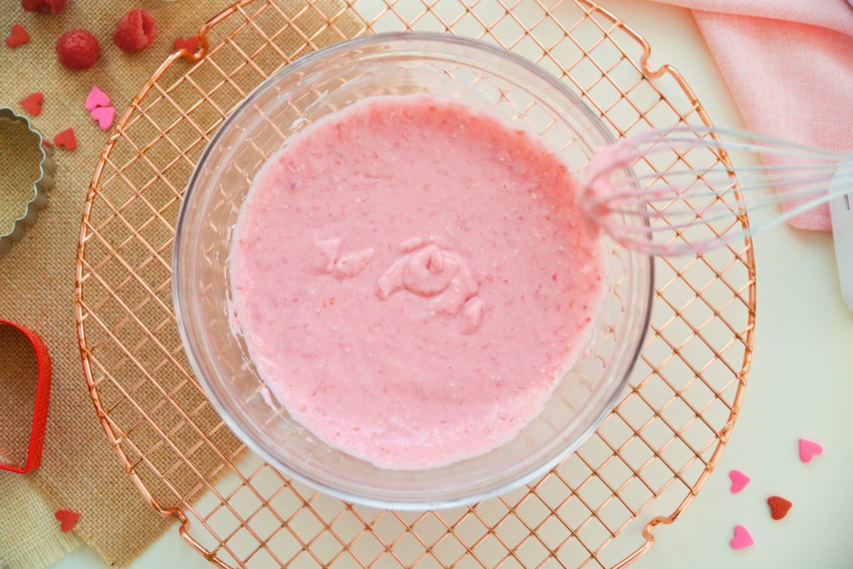 bowl of cream cheese icing glaze with fresh raspberries 