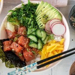 overhead of salmon poke bowl with chopsticks