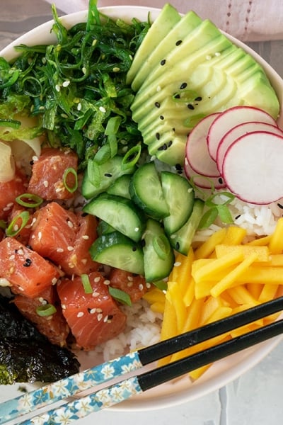 overhead of salmon poke bowl with chopsticks