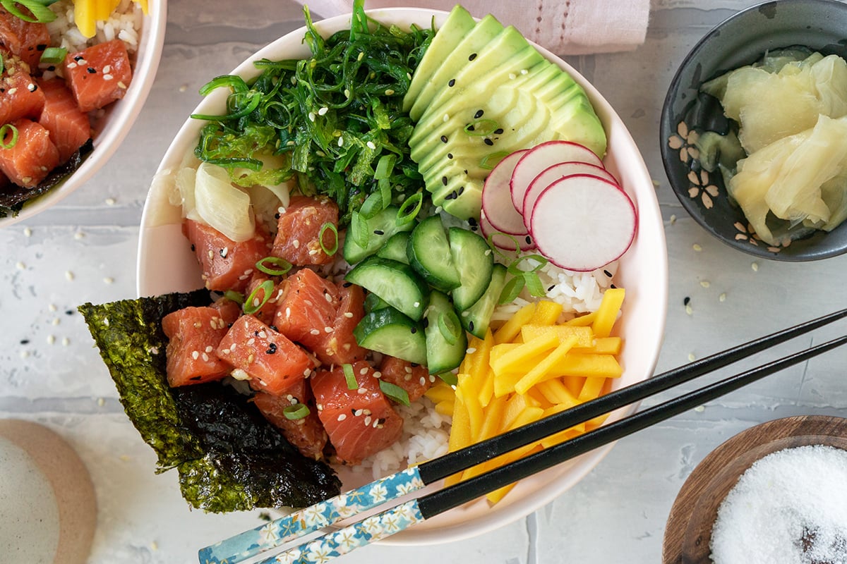 overhead of salmon poke bowl with chopsticks