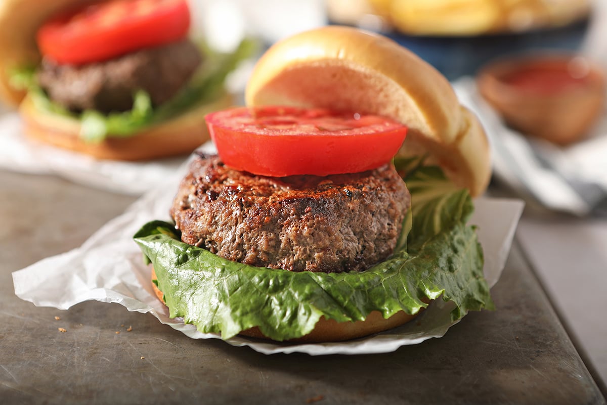 slice of tomato on a hamburger patty  