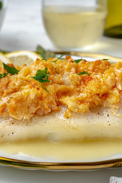 side angle of baked cod topped with lump lobster meat