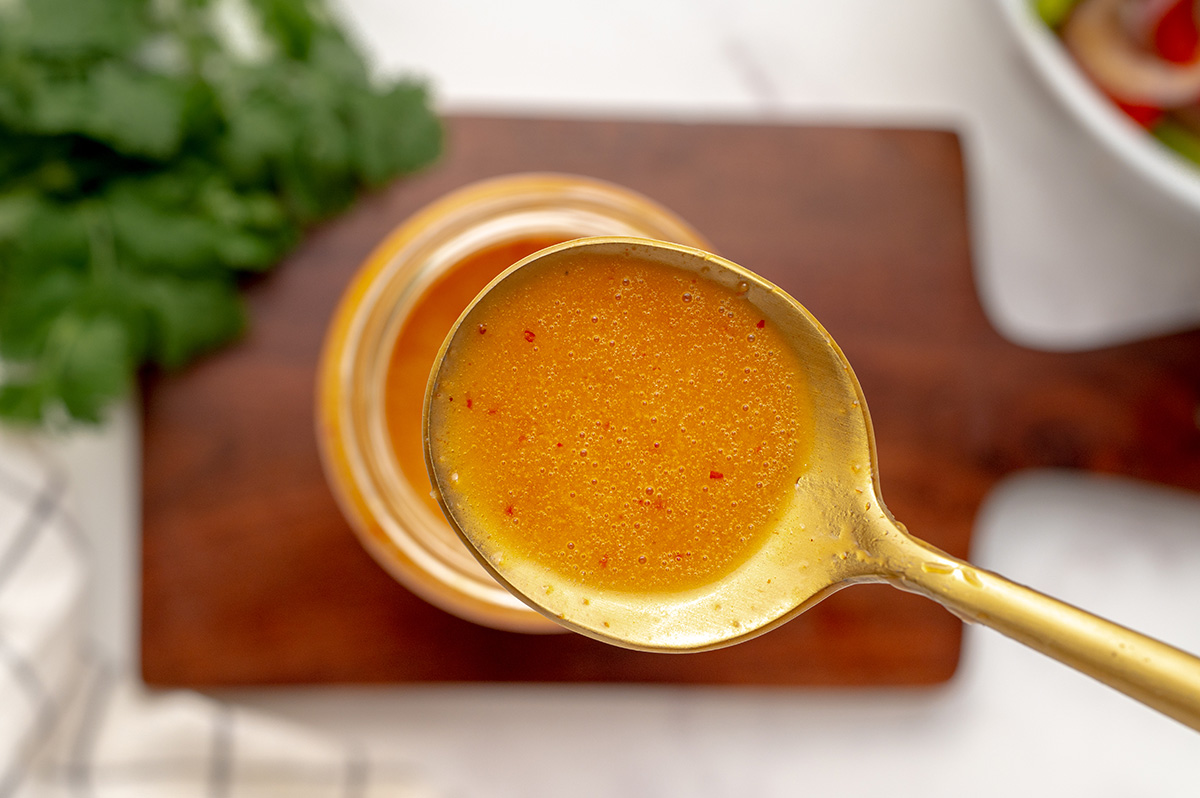 close up of a gold spoon with dressing 