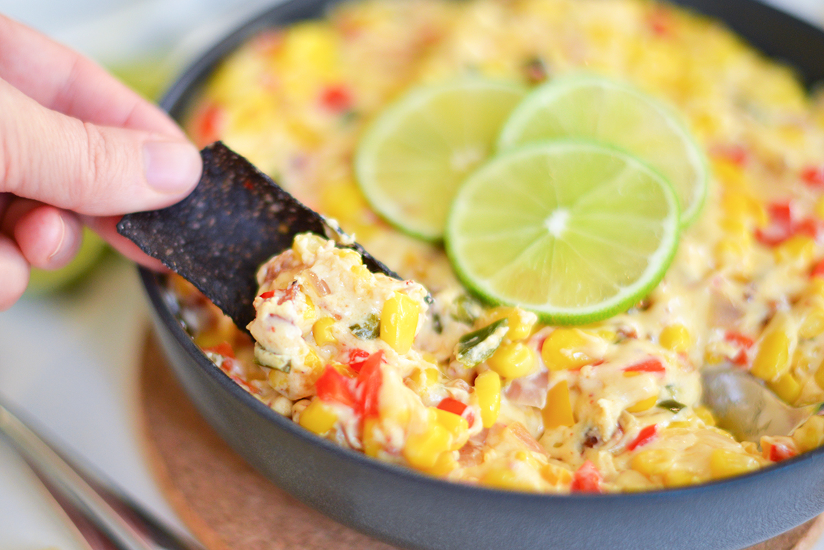 blue corn chip dipping into mexican corn dip recipe