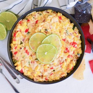 overhead of hot corn dip with limes and chips