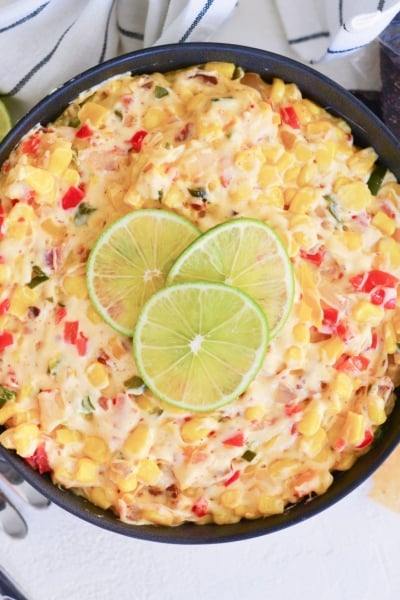 overhead of hot corn dip with limes and chips