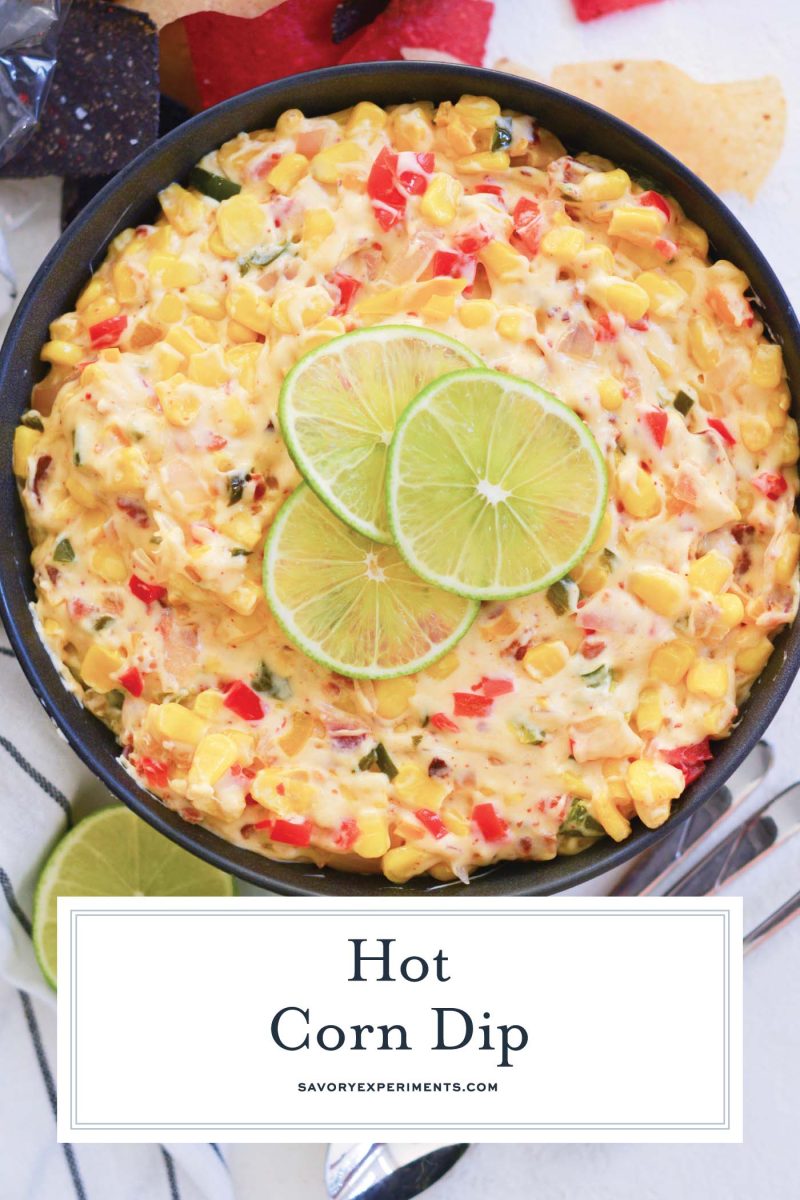 close up of hot corn dip in a cooking vessel with lime slices