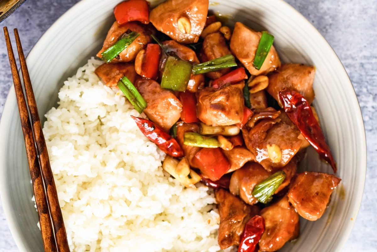close up of kung pao chicken in a bowl with white rice 