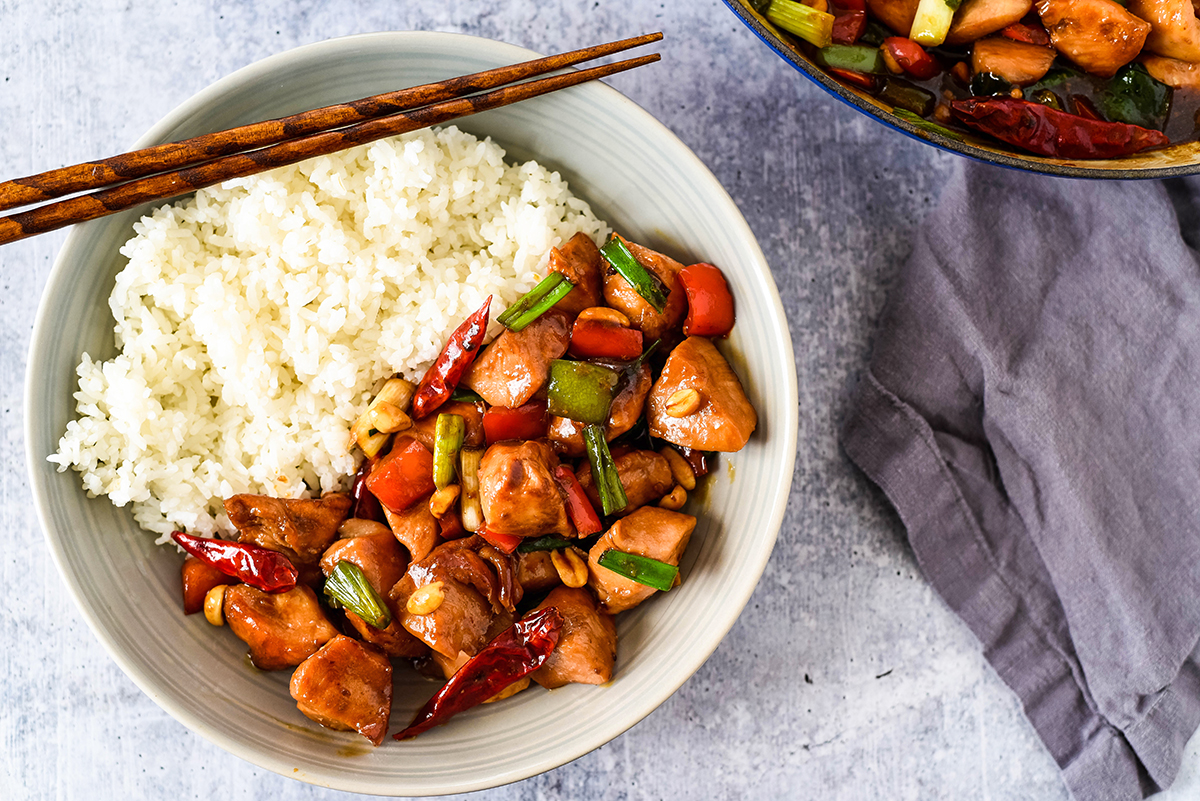 kung pao served in a bowl with the skillet on the side 