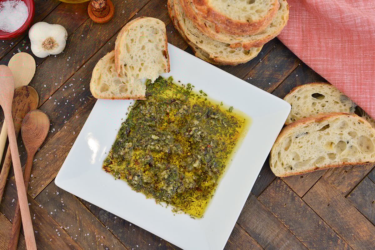 overhead of bread dipping oil with slices of bread 