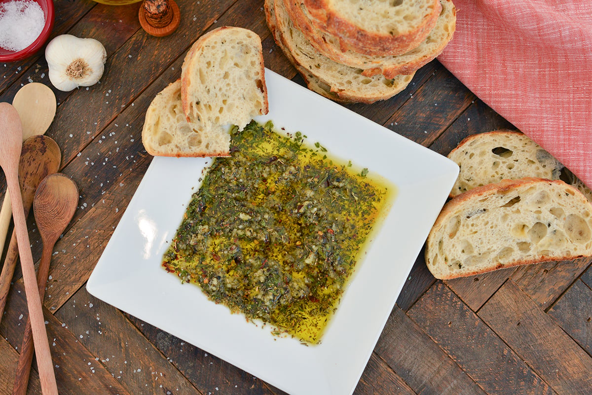 overhead of bread dipping oil with slices of bread 