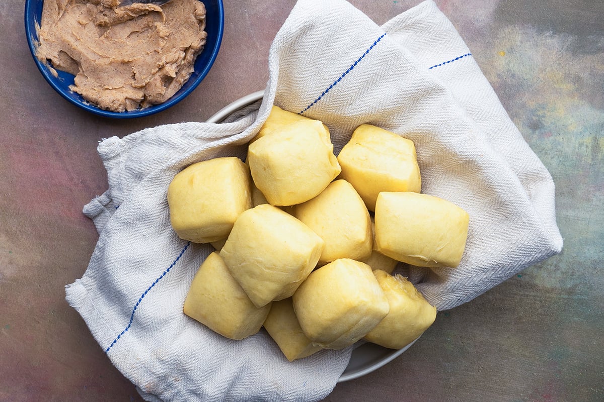 overhead bowl of homemade dinner rolls with a small bowl of cinnamon butter 