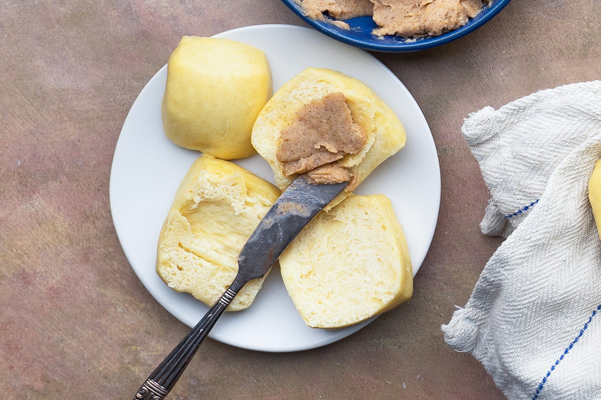 overhead of two rolls on a bread plate with honey cinnamon butter 