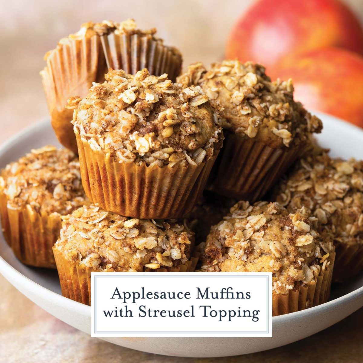 white bowl full of applesauce muffins topped with crumb topping