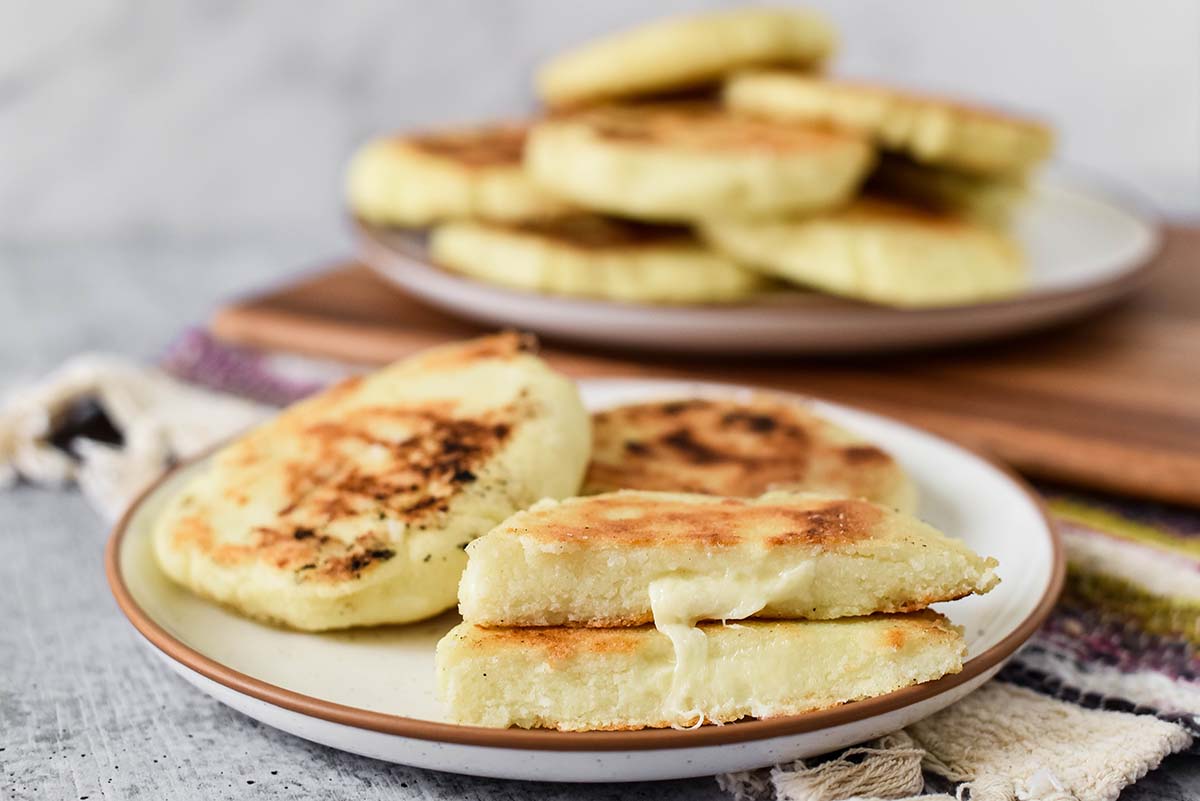 browned cheese arepas on a serving plate 