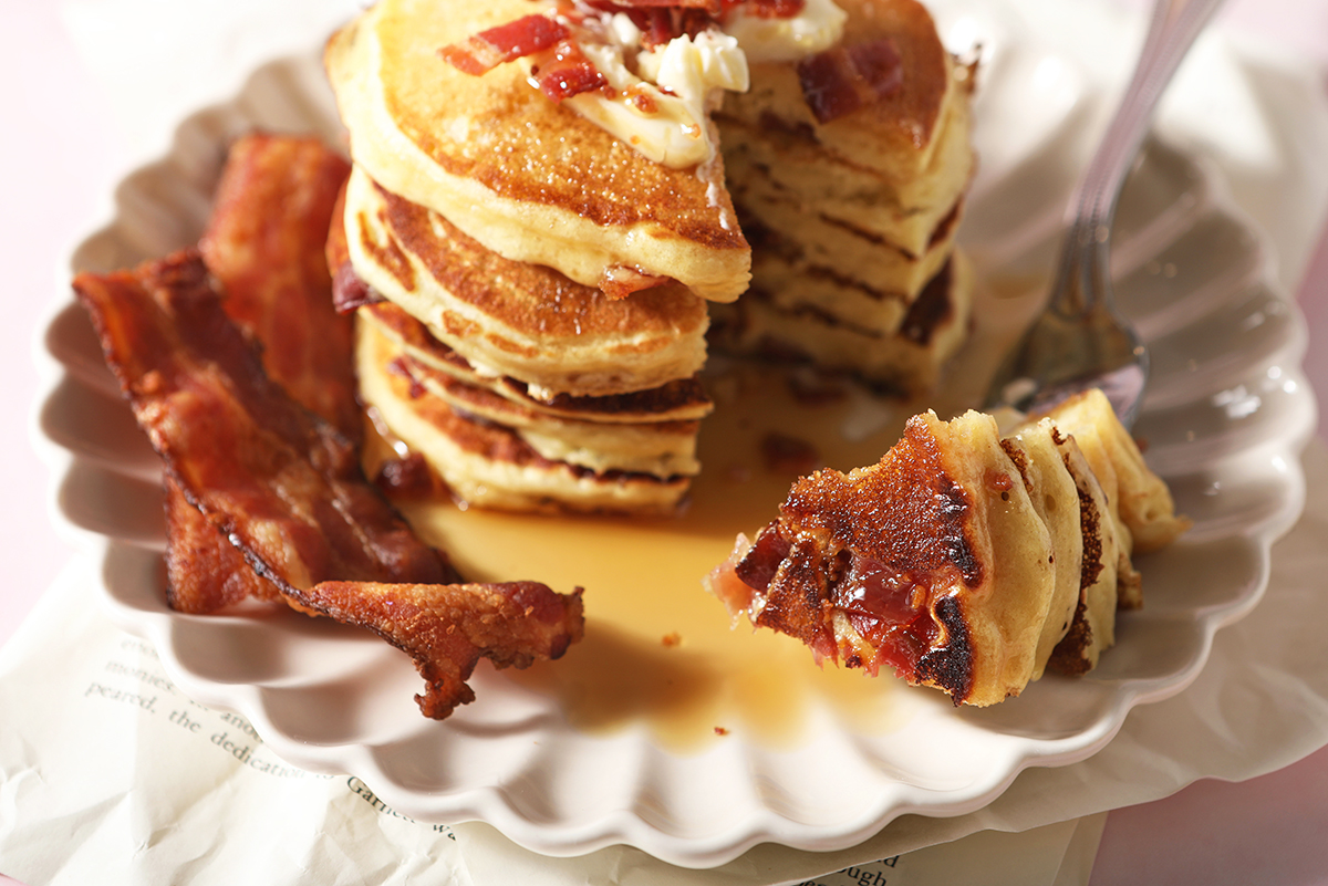 plate of bacon pancakes, some on a fork 