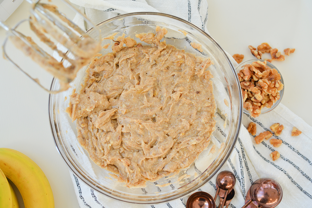 overhead of banana bread batter in a glass mixing bowl 