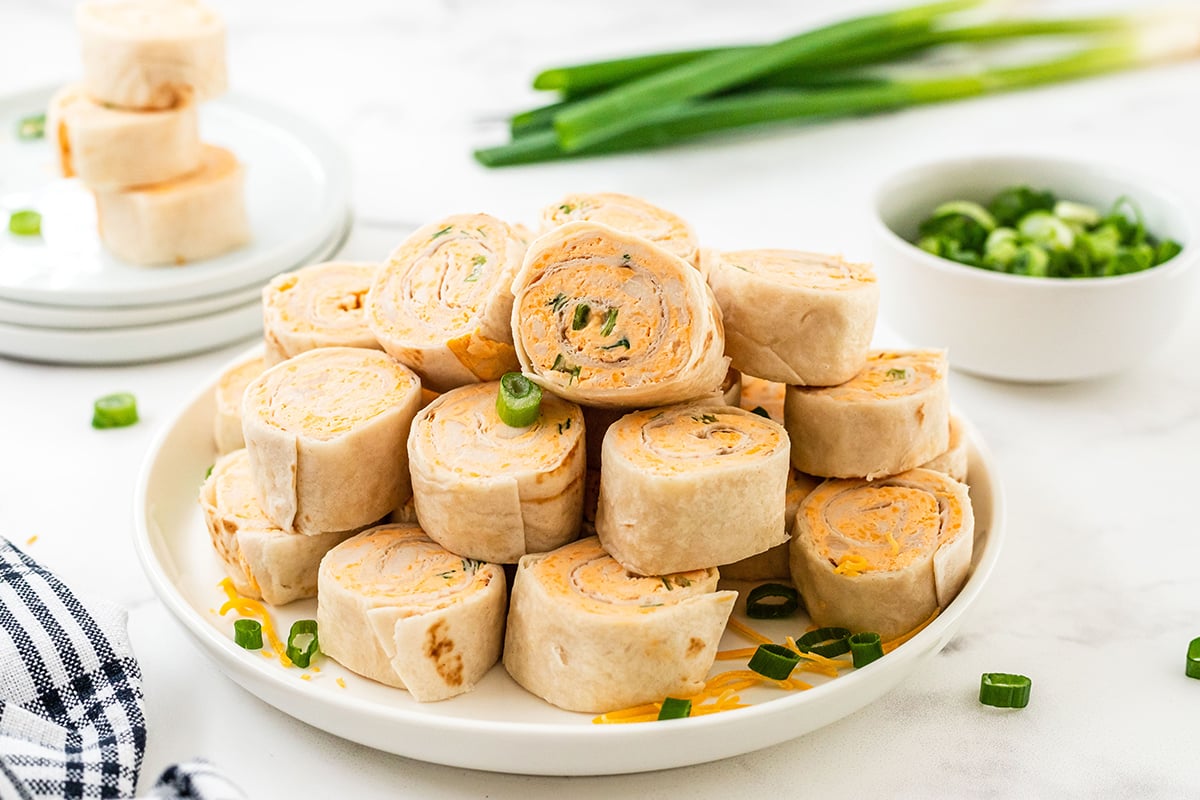 pile of buffalo chicken pinwheels with scallions 