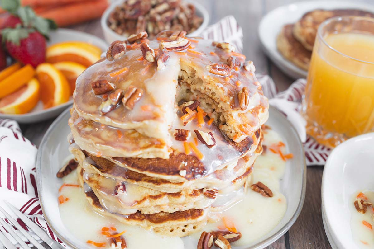 stack of carrot cake pancakes with a edge cut out 