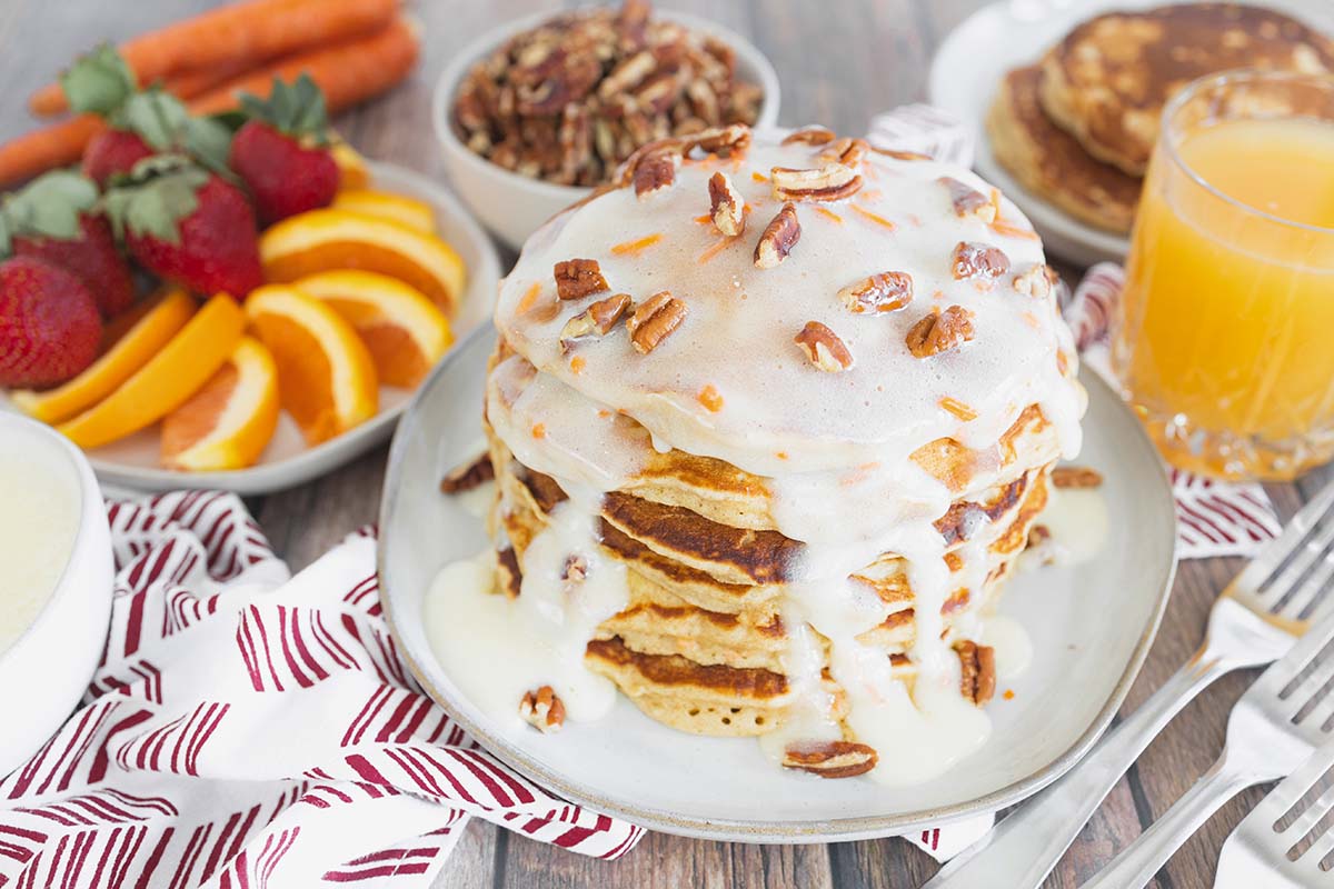 angle stack of pancakes with fruit in the background