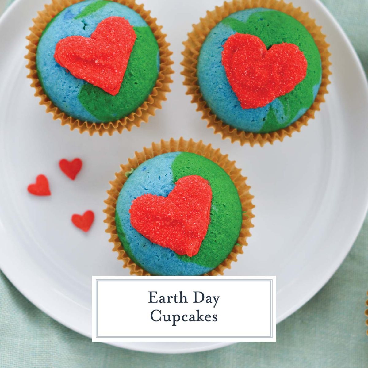 close up of three blue and green cupcakes with red hearts 