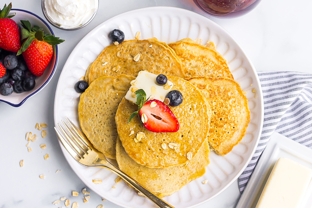 oatmeal pancakes topped with fresh fruit and pat of butter 