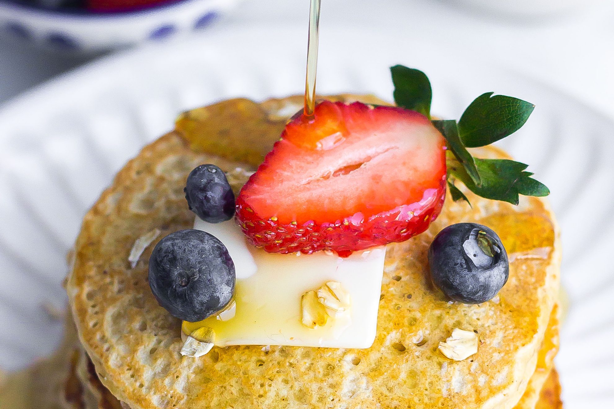 oatmeal pancakes drizzled with maple syrup and fresh fruit