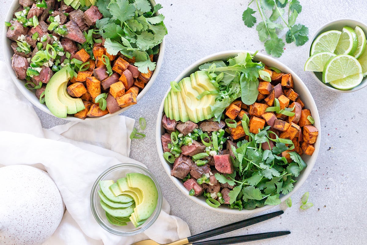 overhead of two dressed steak bowls ready to be served