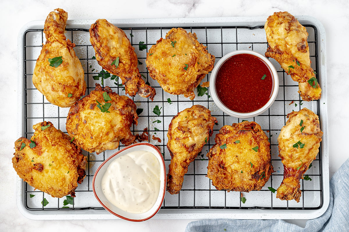 buttermilk fried chicken on wire rack with hot sauce and ranch