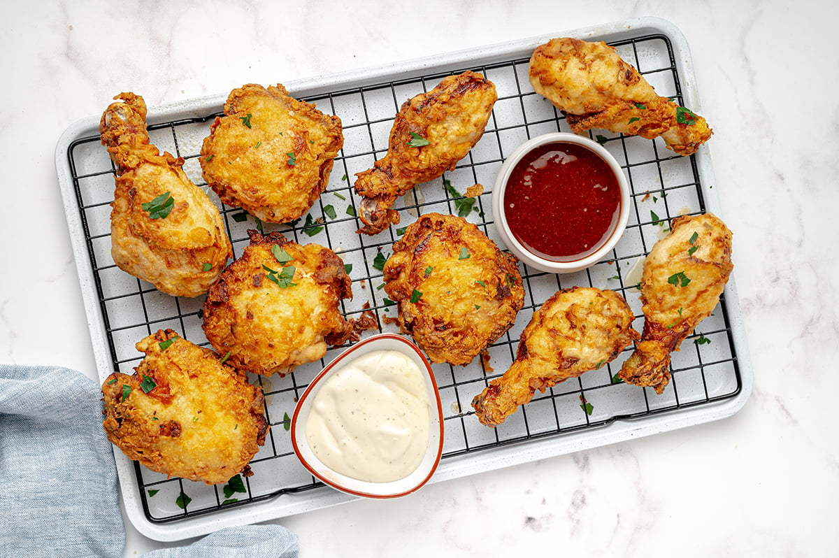 buttermilk fried chicken on wire rack with hot sauce tilted