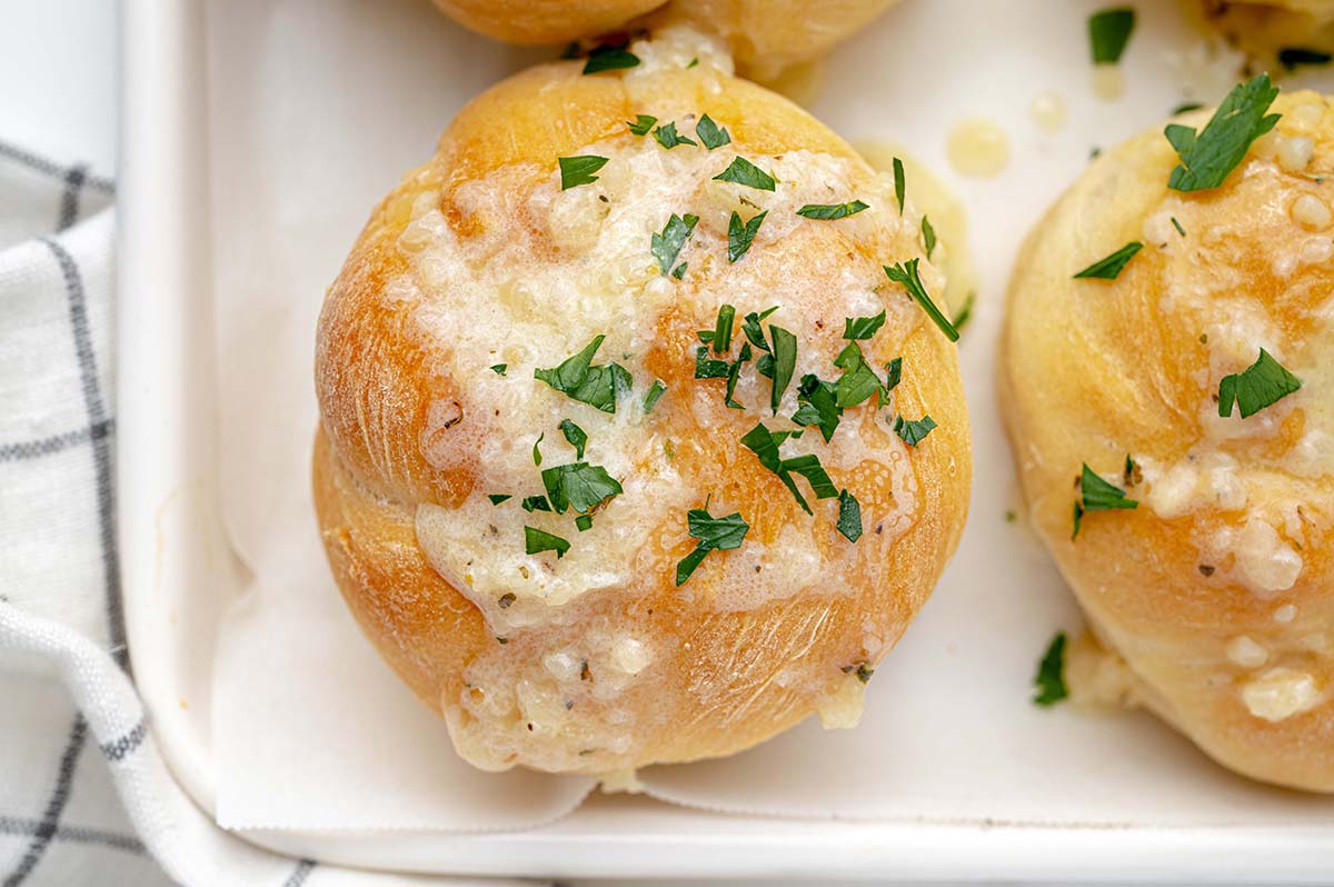 butter drenched bread roll on a white tray 