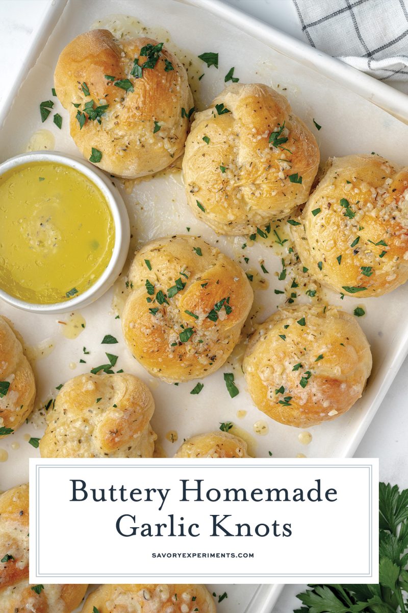 buttery garlic knots on a white baking sheet 