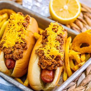 two chili dogs on a tray with onion rings